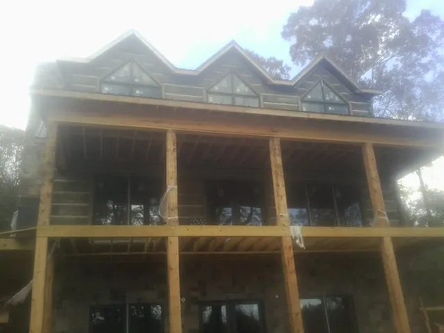 Dormers and porch framing on a large log home under construction — Roof Coating work by our crew in Parsippany